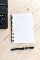 mesa de oficina con cuaderno, bolígrafo y teléfono inteligente foto