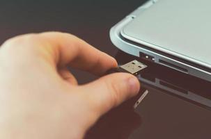 Hand plugging usb flash drive to laptop. photo