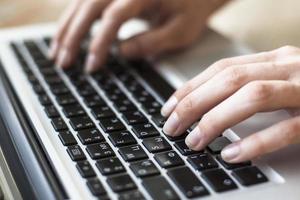 Close-up of female hands typing text on the keyboard photo
