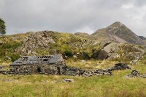 Welsh mountain Cnicht with ruin of stone cottage in foreground