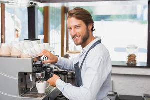 guapo barista haciendo una taza de café foto