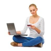 jovencita en jeans con laptop y tarjeta de crédito foto