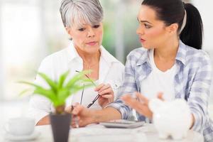 adult daughter helping senior mother with her finances photo