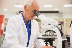 Medical professor working with microscope photo