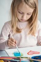 niña dibuja con pinceles foto