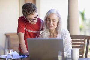 Grandmother and grandson using laptop photo