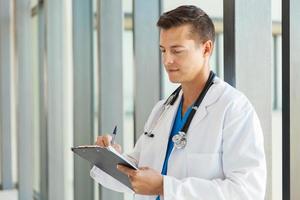 medical intern doctor writing on clipboard