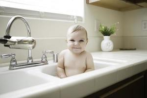 lindo bebé en el fregadero foto