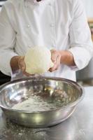 Baker forming dough in mixing bowl