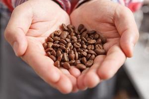 Close-up of person holding coffee beans