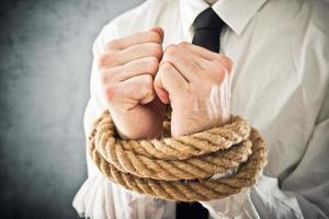 Businessman with hands tied in ropes photo