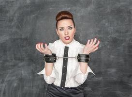 Business woman with handcuffs on her hands