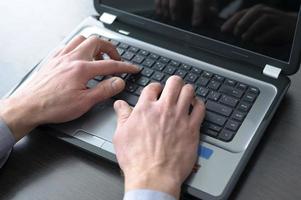 Businessman hands on laptop keyboard