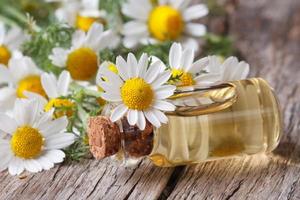 oil in a glass bottle on the background of camomile photo
