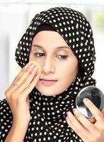 woman with cotton pad applying face powder