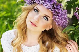 Jovencita rubia con corona de flores lilas foto