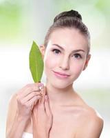 beautiful woman face portrait with green leaf photo