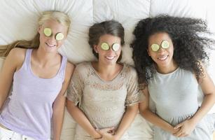 Happy Teenage Girls With Cucumber Slices On Their Eyes photo