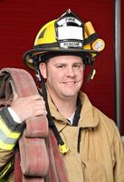 A handsome fire fighter smiling at the camera photo
