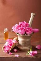 mortero con flores rosas para aromaterapia y spa foto