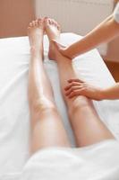 Mujer joven que recibe masaje de piernas en el spa center cuidado del cuerpo