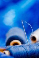 needle with blue thread, shallow depth of field