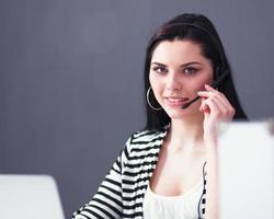 Beautiful business woman working at her desk with headset and