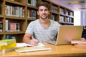 estudiante estudiando en la biblioteca con laptop foto