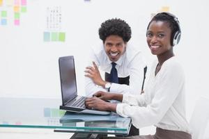 Smiling business coworkers using laptop