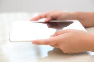 Mujer mano toque tableta blanca con pantalla vacía en blanco foto