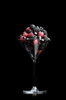moras frescas, grosellas negras y frambuesas en el martini foto