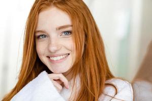 Portrait of a happy redhead woman in bathrobe photo