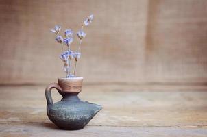 flor de lavanda en botella en mesa de madera foto
