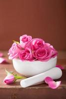 mortar with rose flowers for aromatherapy and spa photo