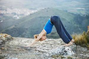 Caucasian woman performing downward dog yoga pose photo