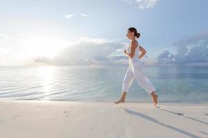 Caucasian woman jogging at the seashore photo