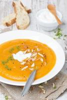 carrot soup with almonds, yogurt and watercress in a plate
