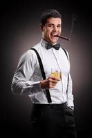 Young guy smoking cigar and drinking whiskey photo