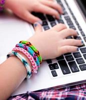 Young girl with loom bracelets on laptop