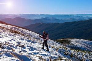 Un excursionista caminando sobre nieve hielo terreno amplia vista a la montaña