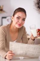 Happy young woman having healthy breakfast in kitchen photo