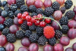 Blackberries, gooseberries, redcurrants, blackcurrants on a wooden table photo