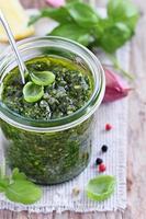 Basil pesto on a rustic wooden table photo
