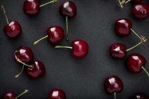 Red cherries on black background photo