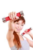 young Japanese woman doing dumbbell exercises photo