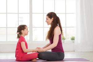 Young mother and daughter doing yoga exercise photo