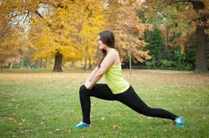 Woman performs stretching before jogging photo