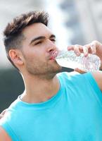 Young athlete drinking water after exercise