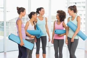 Fit smiling young women with exercise mats photo