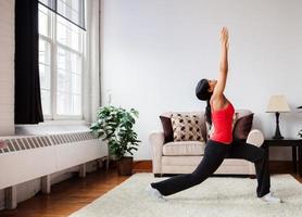 Young woman exercising in a living room photo